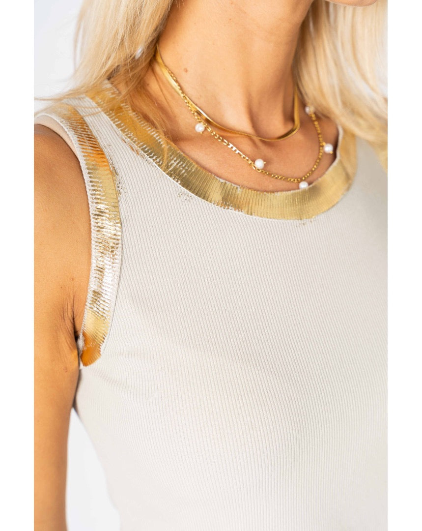 Close-up of a person wearing a gold necklace with a white background