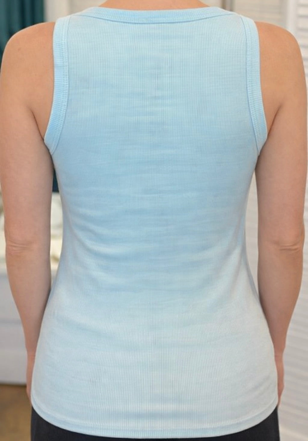 Back view of Alessia Tank in light blue ribbed knit with gold trim detail at neckline and straps.