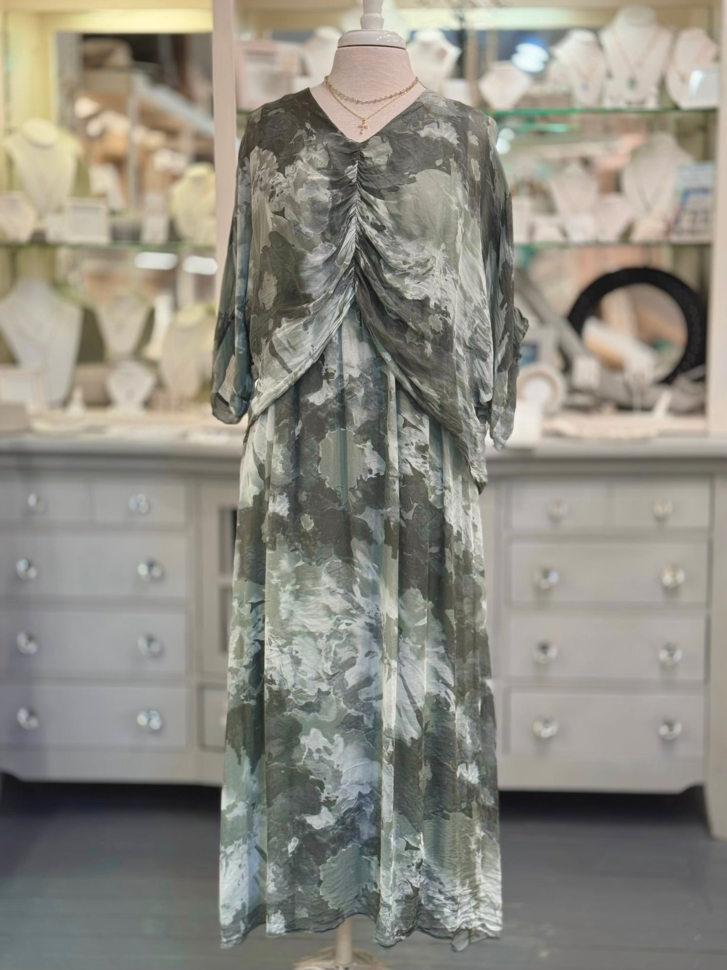 Ariella Silk Dress in Olive with ruched front and draped overlay on a mannequin at Ardor Boutique.