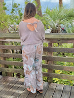 Back view of Briella taupe shimmer sweater showing ribbon bow detail and open-back design