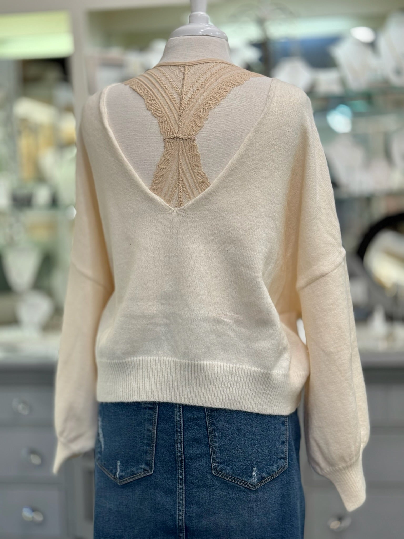 Back view of Ren Reversible Cropped Sweater in cream showing V-neck with strap detail.