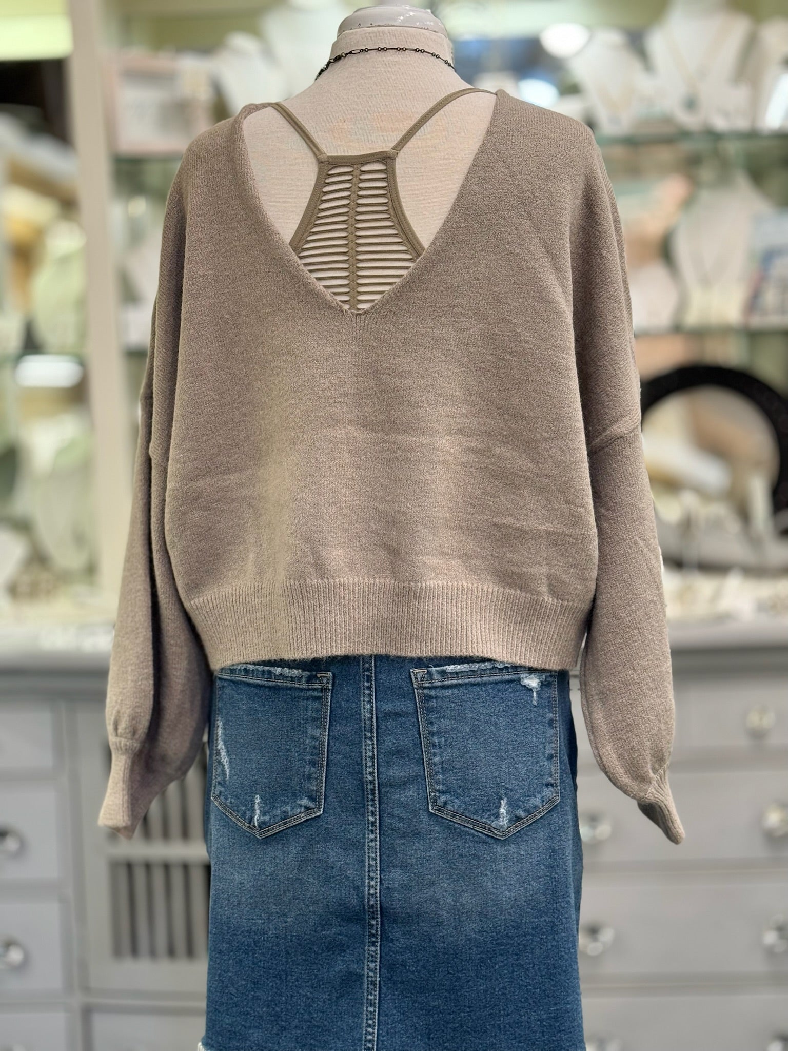 Back view of mocha reversible cropped sweater styled with taupe racerback bralette and V in the back