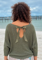 Back view of the Briella olive shimmer sweater showing the ribbon bow, back opening and relaxed fit.