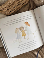 Open children's book with illustrations of three children.