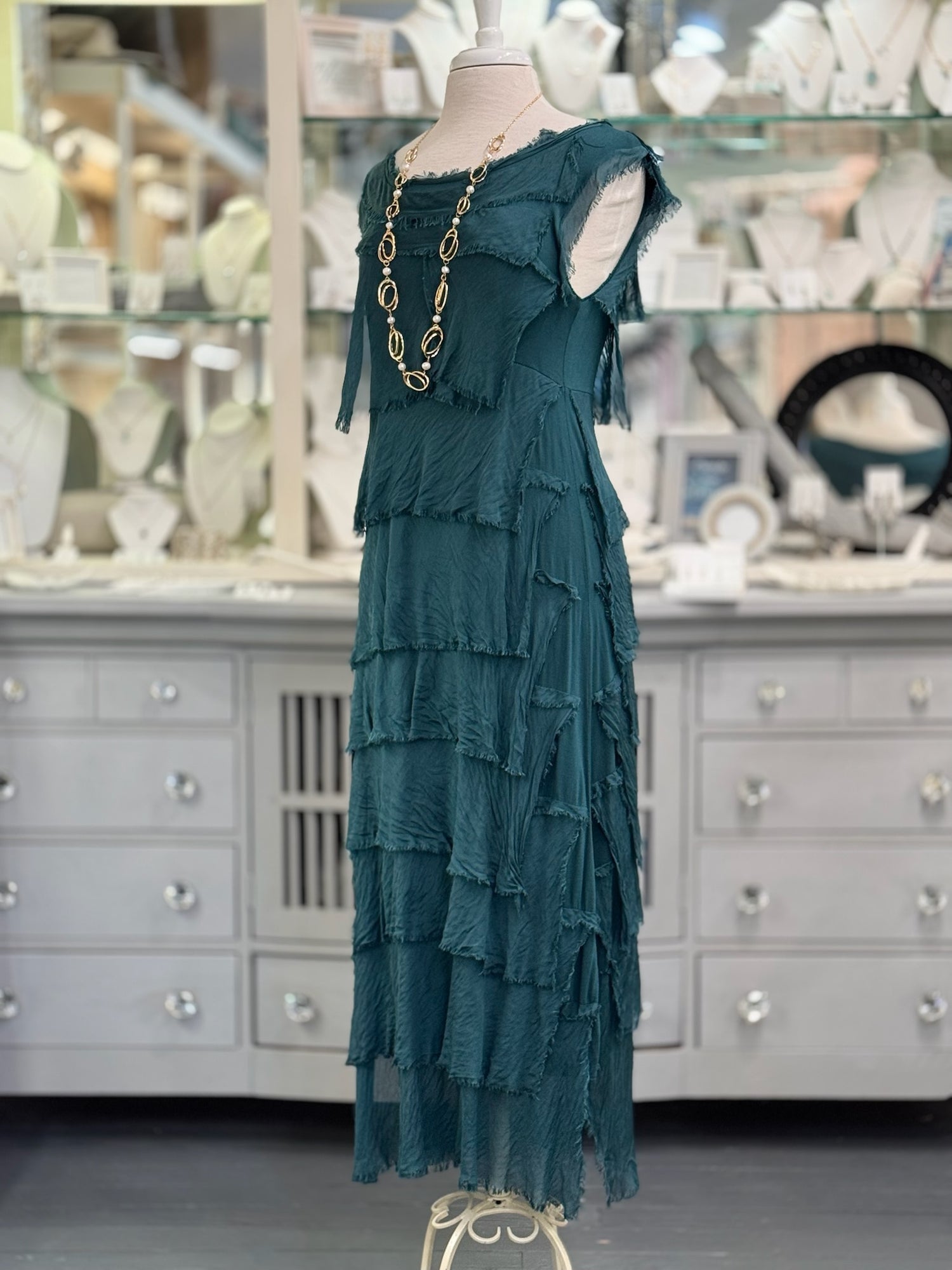 Detail of the layered silk tiers on the Briella Dress highlighting the lightweight texture and drape. Paired with long pearl and gold necklace