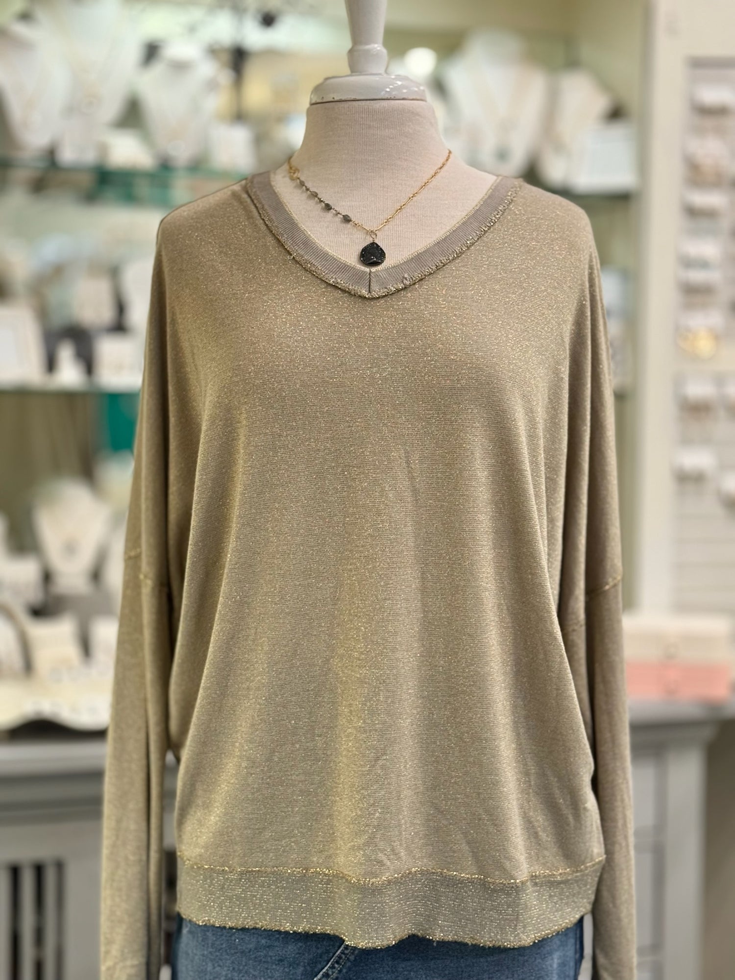 Mannequin wearing The Celeste Top in mocha, a lightweight metallic knit sweater with soft shimmer and ribbed V-neckline.