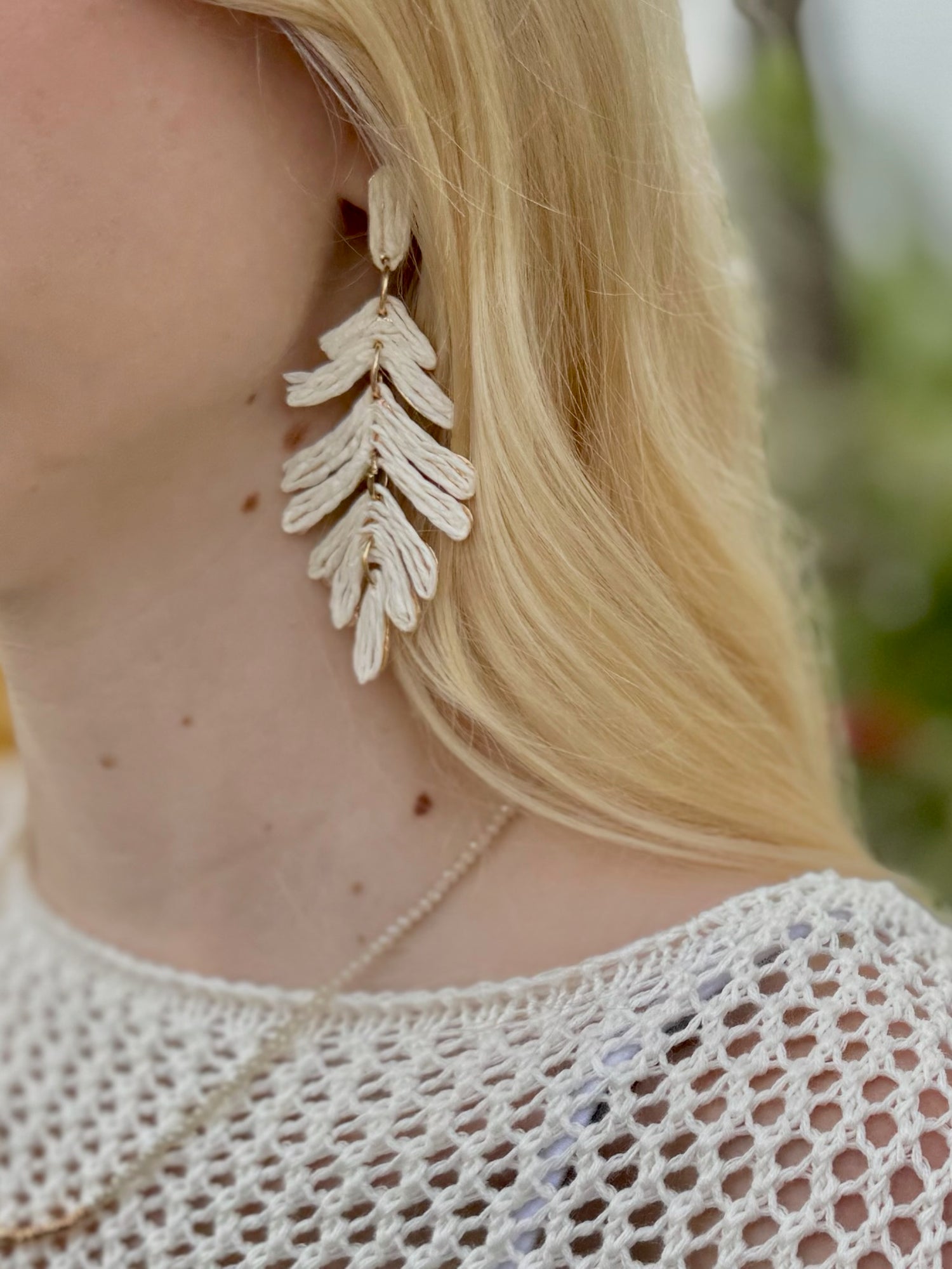Charisma Earrings in Cream shown on model styled with crochet neural sweater and beige beaded necklace