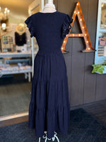 Navy maxi dress with a smocked bodice, V-neckline, ruffle short sleeves and a flowing tiered skirt at Ardor Boutique.