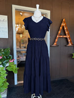 Navy maxi dress with a smocked bodice, V-neckline, ruffle short sleeves and a flowing tiered skirt at Ardor Boutique.