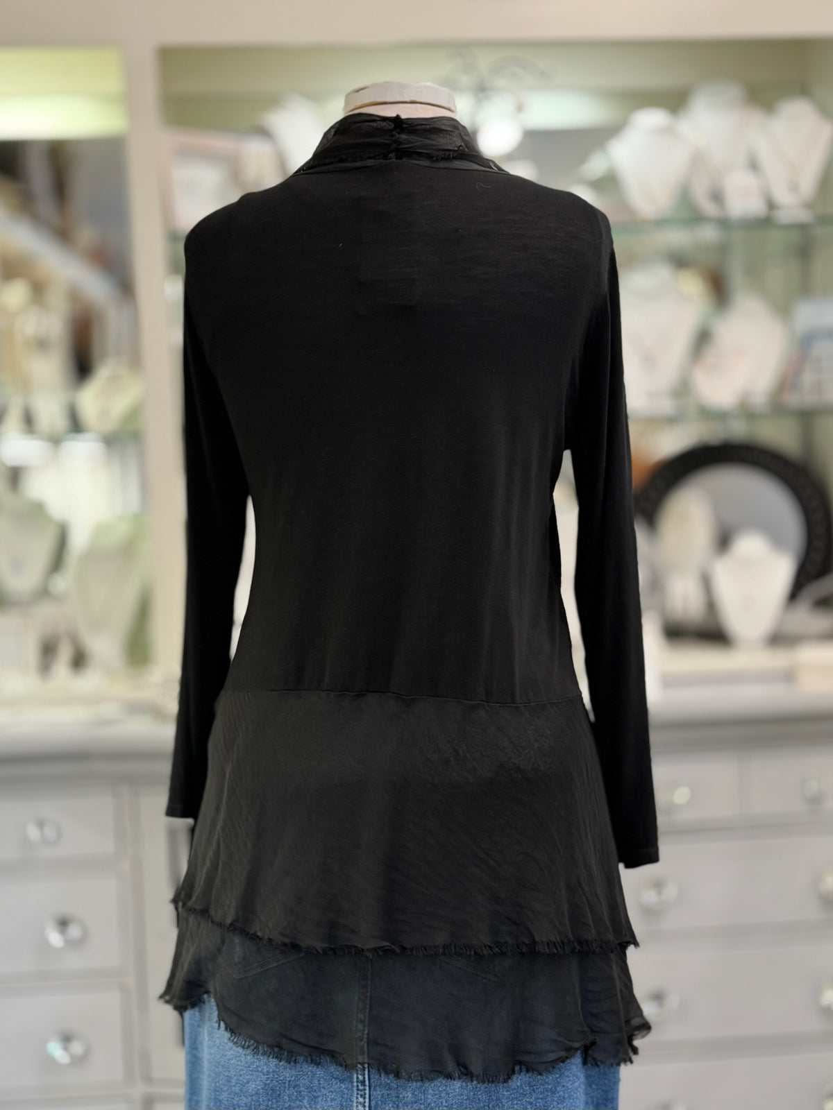 Clara Cardigan in black featuring long sleeves, raw-edge train detailing , and an asymmetrical hem, displayed at Ardor Boutique.