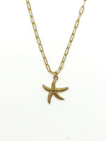 Gold starfish pendant necklace on a white background