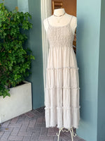 Cream sleeveless tiered midi dress with textured bodice displayed on mannequin