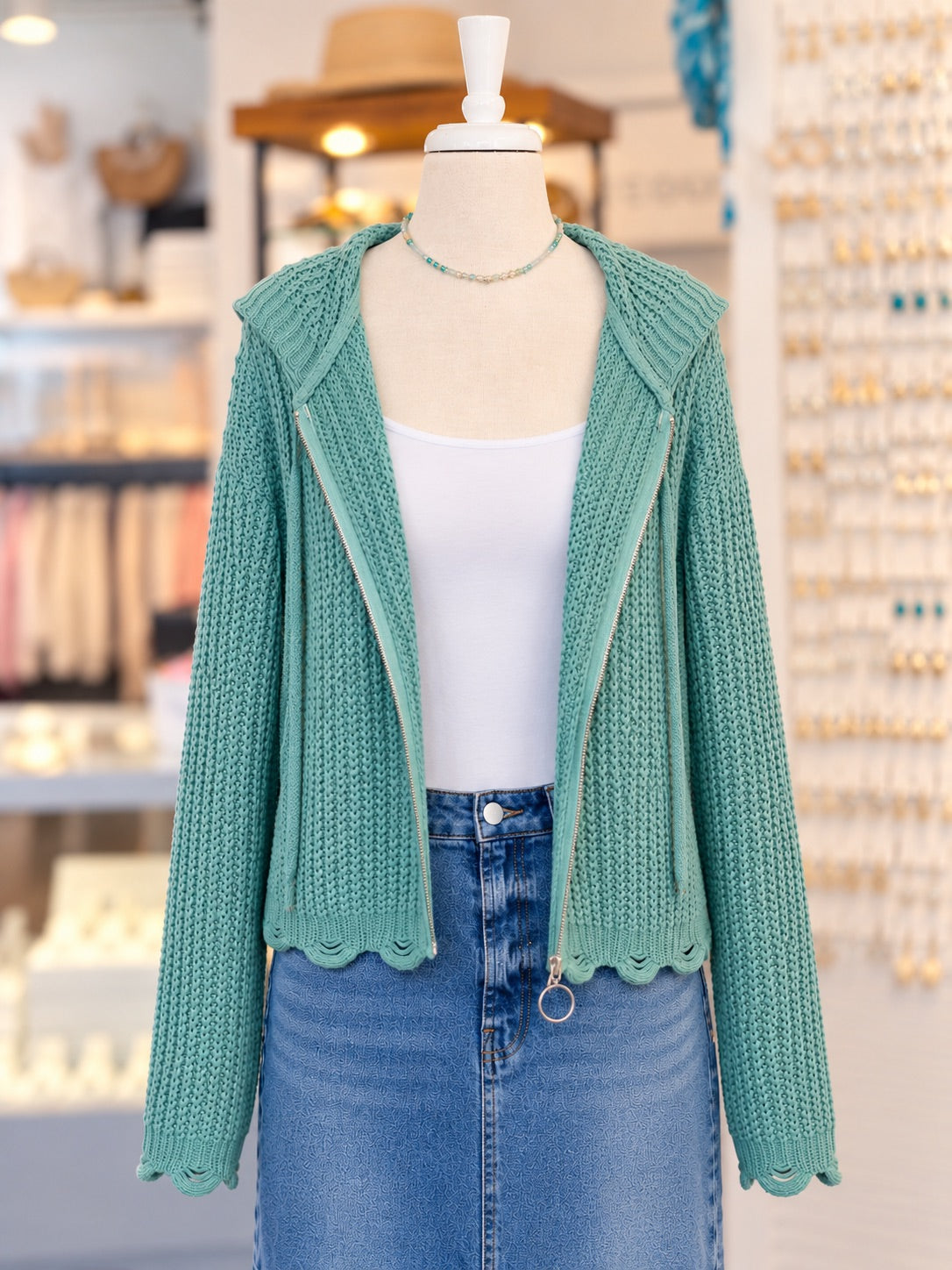 Kennedy Hoodie in teal featuring textured open knit, a full zipper with ring pull, hood with drawstrings, and cropped scalloped hem, styled with denim at Ardor Boutique.