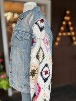 Side detail of the Dahlia Denim Jacket highlighting the hand-crocheted granny square sleeve in ivory with colorful floral motifs and distressed denim shoulder at Ardor Boutique.