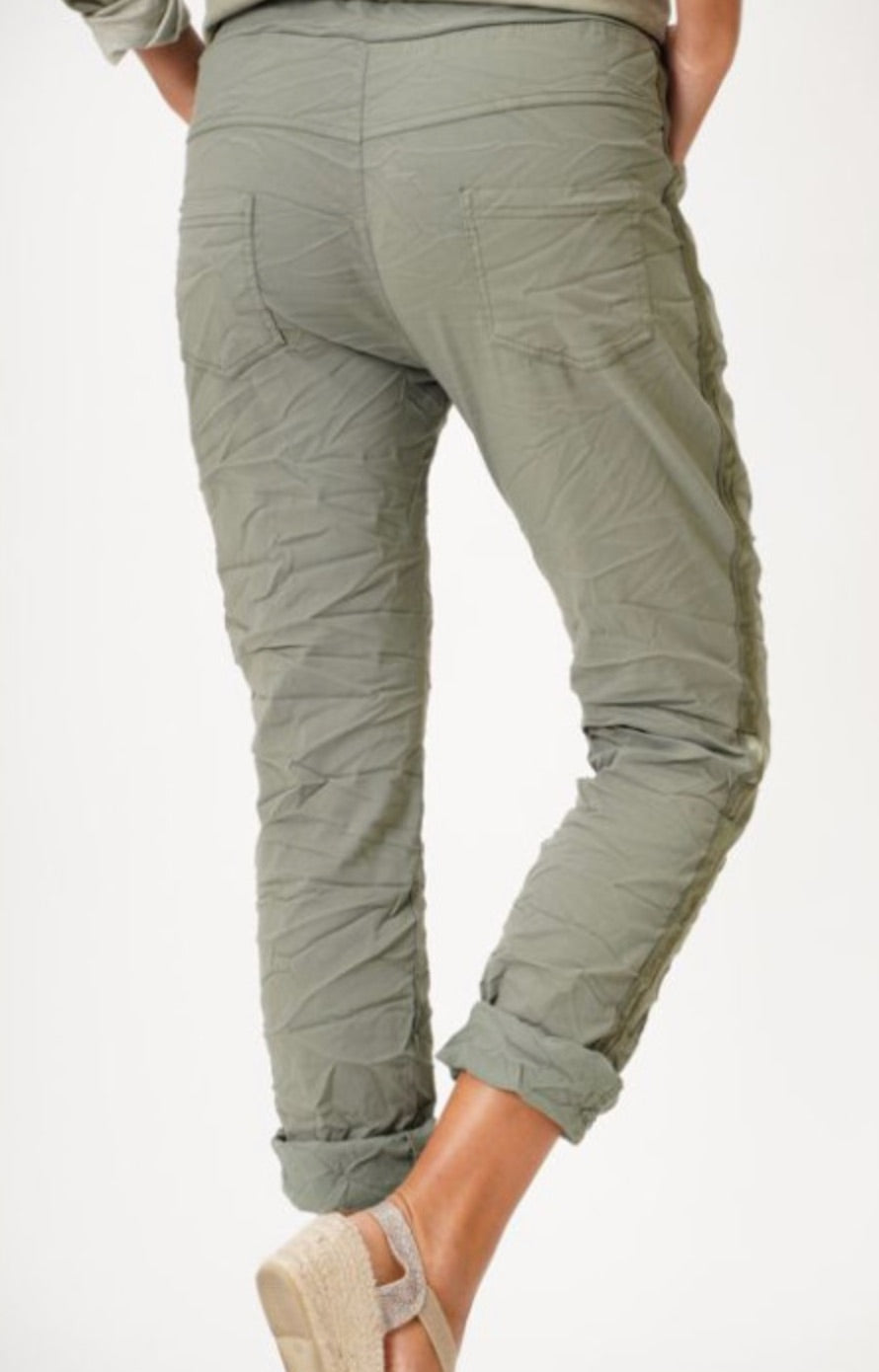 Back view of olive green crinkle jeggings with pockets and rolled hem.