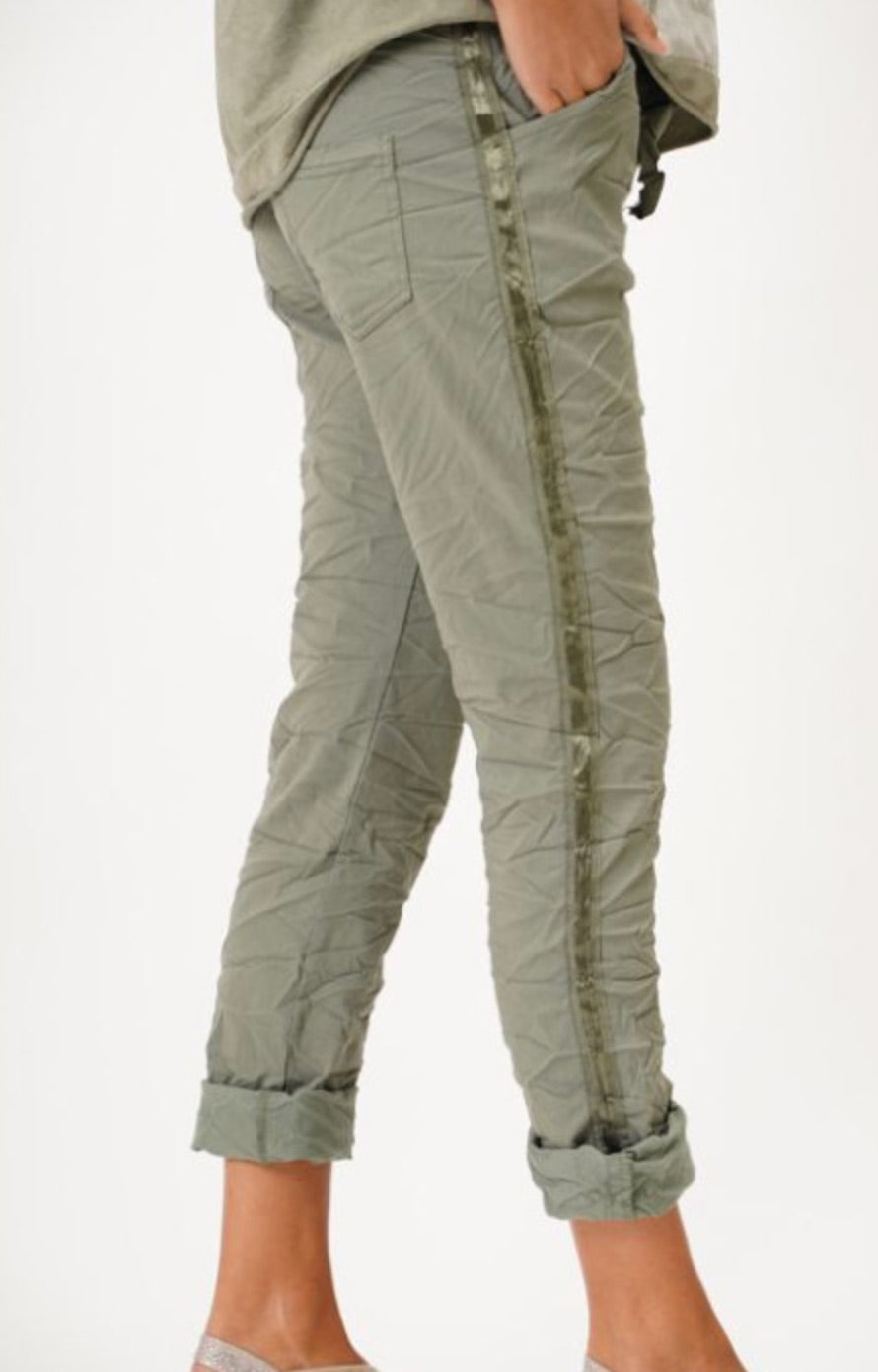 Side view of olive green Italian jeggings with tonal stripe and rolled hem.