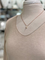 Close-up of blush knit top neckline and soft sheer texture.