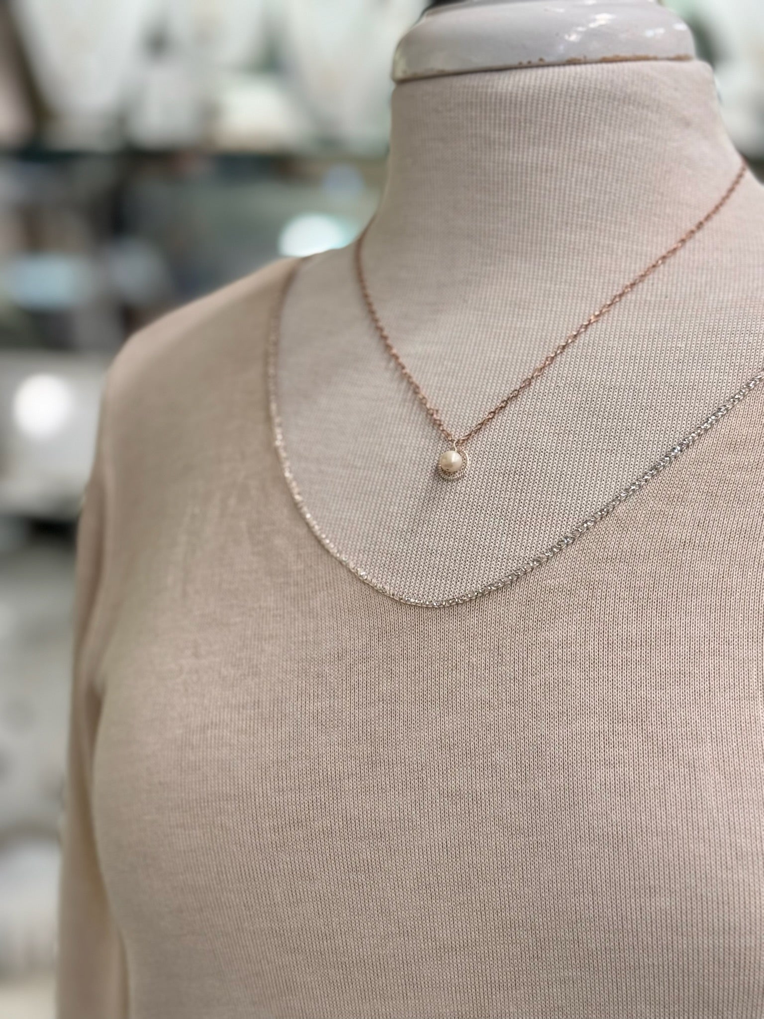 Close-up of blush knit top neckline and soft sheer texture.