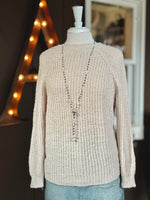 Ell Sweater shown reversed: worn with the smooth crew neckline in front, styled with a long beaded necklace and denim.
