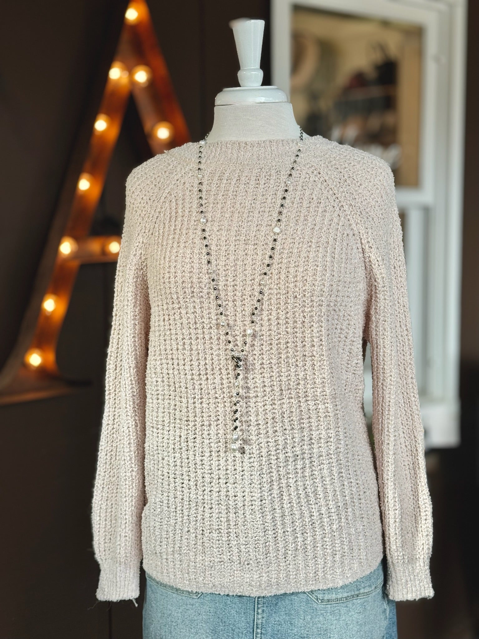 Ell Sweater shown reversed: worn with the smooth crew neckline in front, styled with a long beaded necklace and denim.