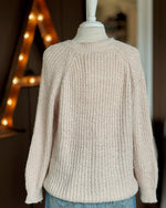 Back view of neutral textured sweater on a dress form showing relaxed fit in a soft waffle knit.