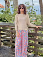 Front view of Briella gold shimmer sweater styled with colorful wide-leg pants
