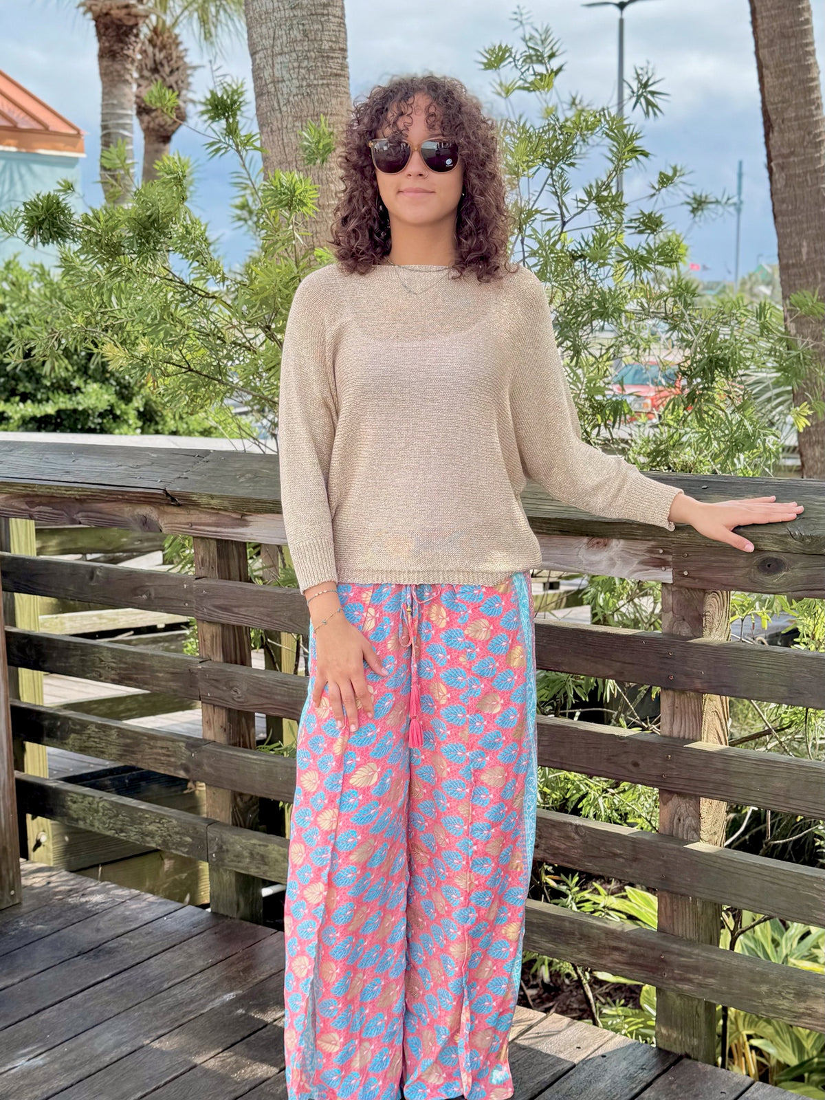 Front view of Briella gold shimmer sweater styled with colorful wide-leg pants