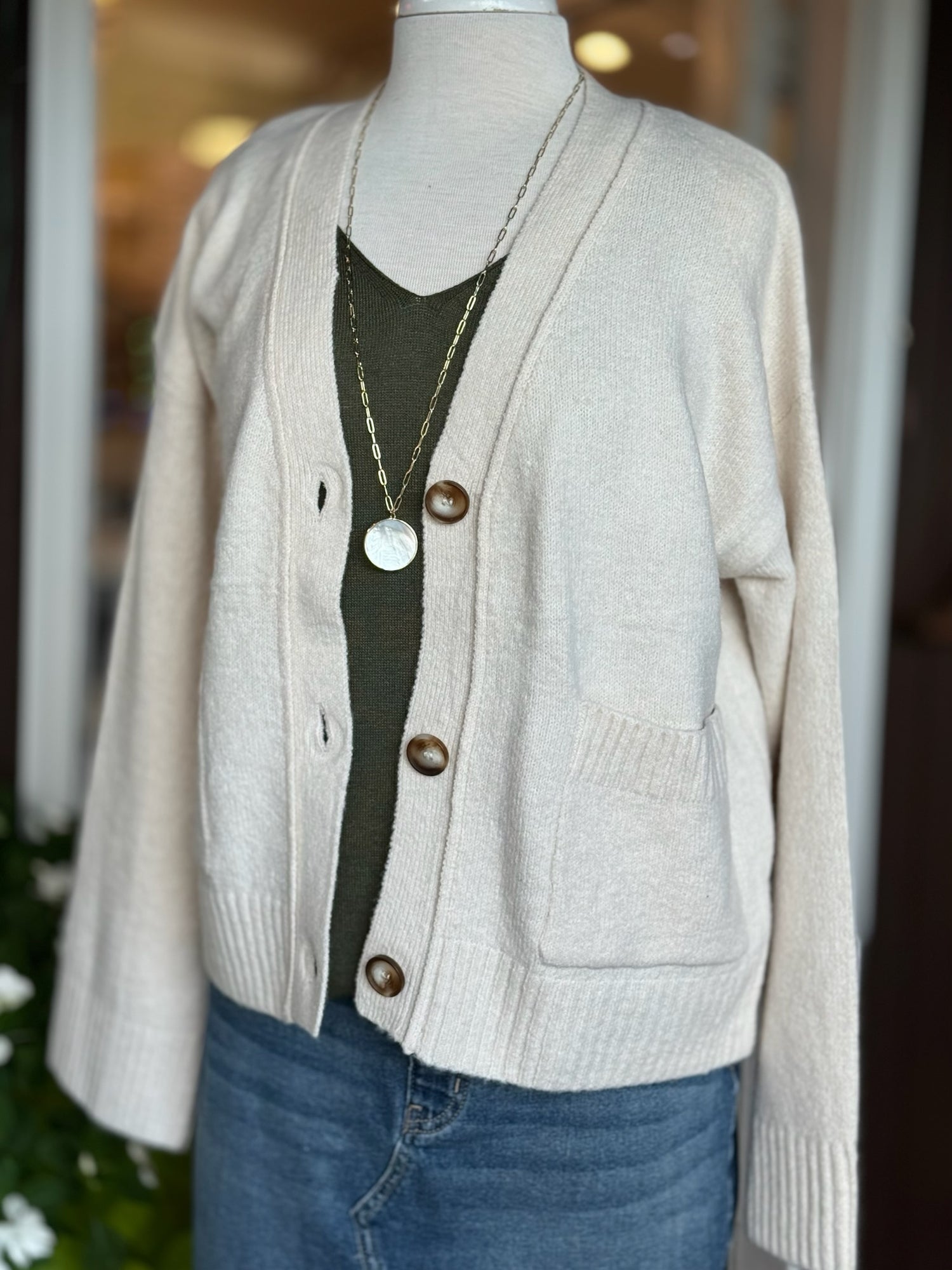 Front view of Jody Button Cardigan in cream with relaxed fit, button closure, and front pockets.