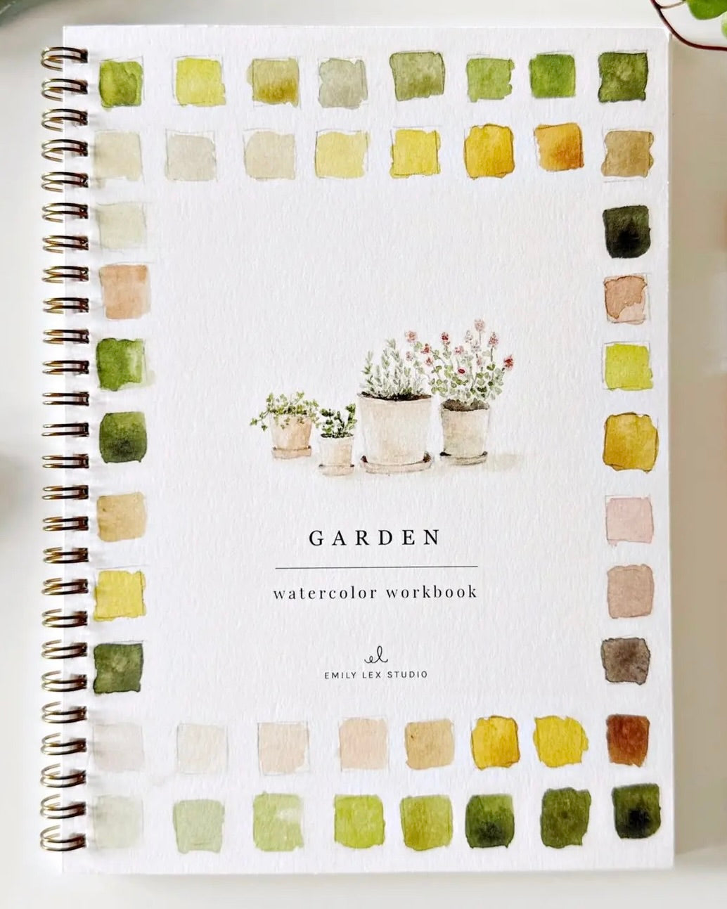 Garden watercolor workbook by Emily Lex with spiral binding and botanical cover art featuring watercolor swatches around the border