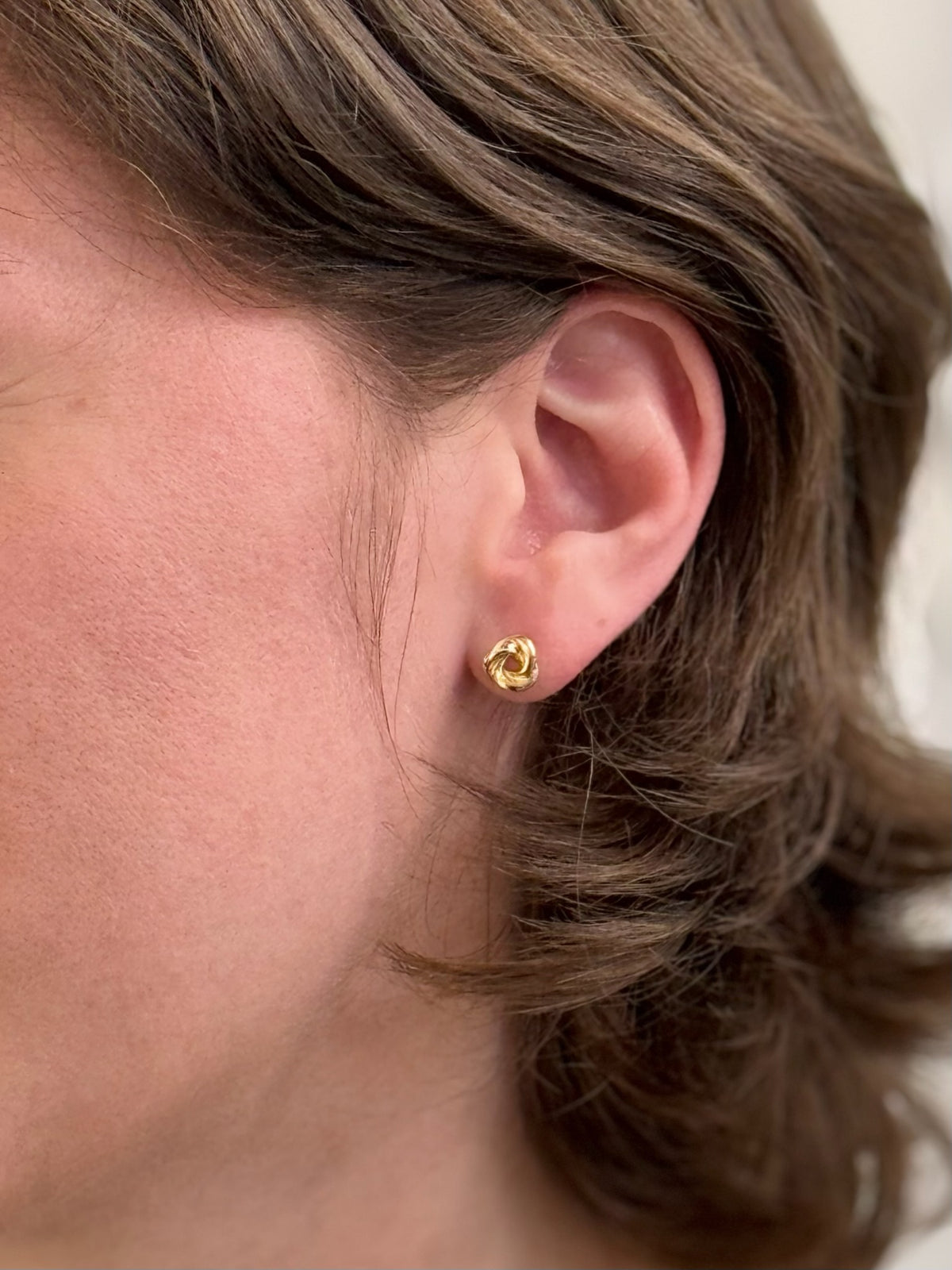 Gold Knot Stud Earrings being worn