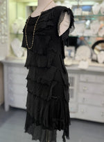 Side view of the Gianna black silk dress at Ardor Boutique, highlighting the sleeveless design, textured silk layers, and delicate frayed edges.