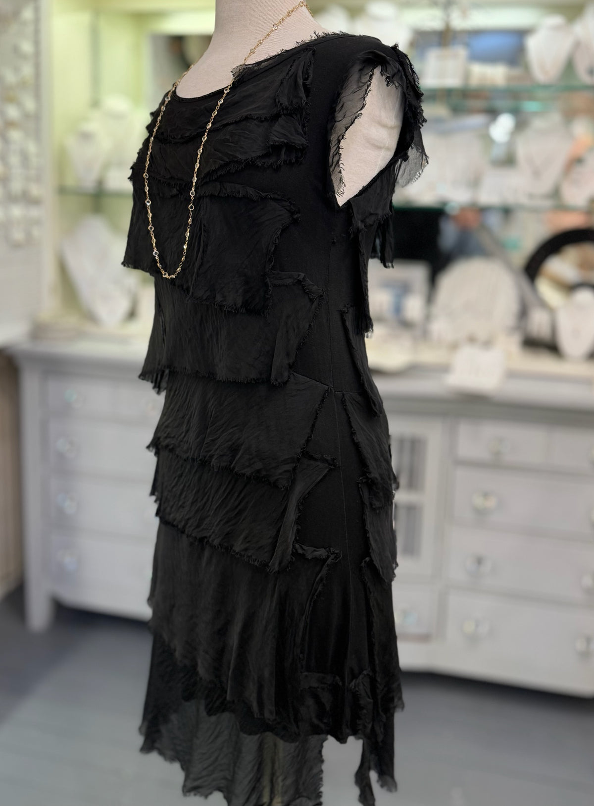 Side view of the Gianna black silk dress at Ardor Boutique, highlighting the sleeveless design, textured silk layers, and delicate frayed edges.