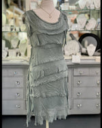 Gianna Italian silk dress in olive displayed on a mannequin at Ardor Boutique, featuring a scoop neckline, asymmetrical silk tiers, and frayed trim.