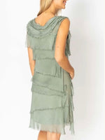 Model showing the back and side of the Gianna olive Italian silk dress from Ardor Boutique, highlighting the layered silk tiers, frayed trim, and flowing hem.