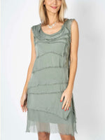 Model wearing the Gianna Italian silk dress in olive from Ardor Boutique, featuring a sleeveless scoop neckline, flowing silk layers, and a shorter hem.