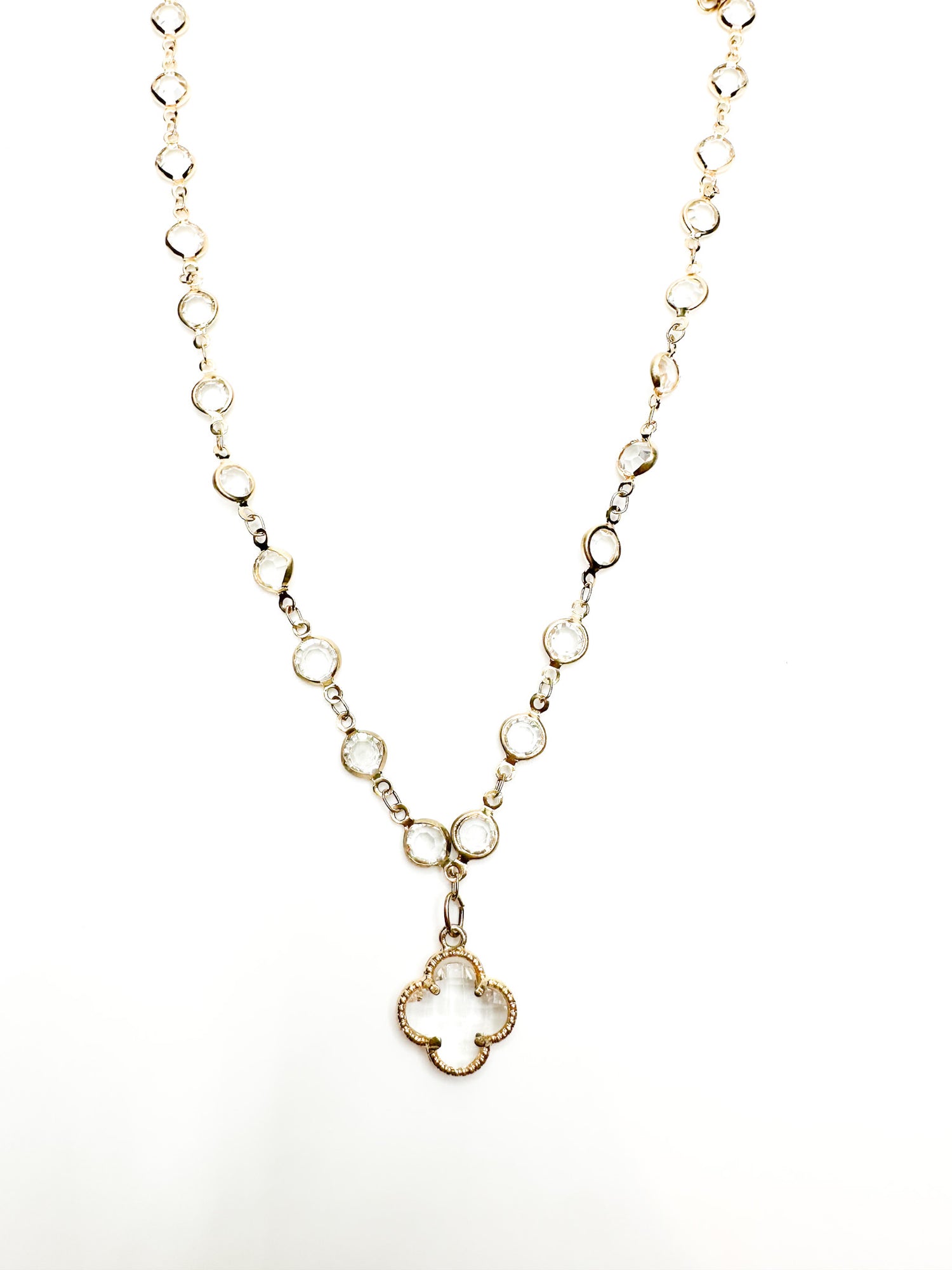 Gold necklace with a clover-shaped pendant on a white background