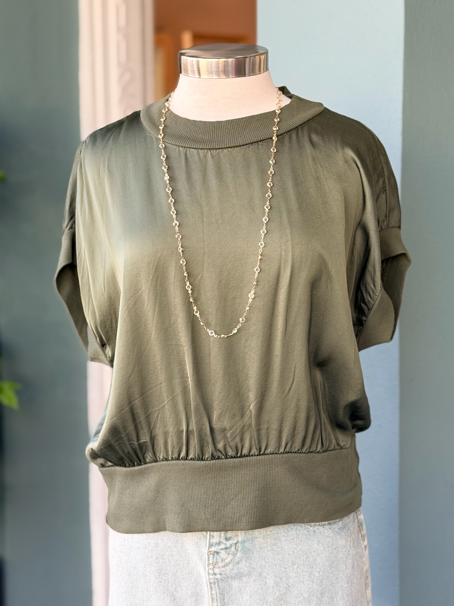 Green blouse on a mannequin with a blurred background