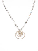 A sterling silver necklace with a swirled design pendant and a clear crystal drop in the center, displayed against a white background.