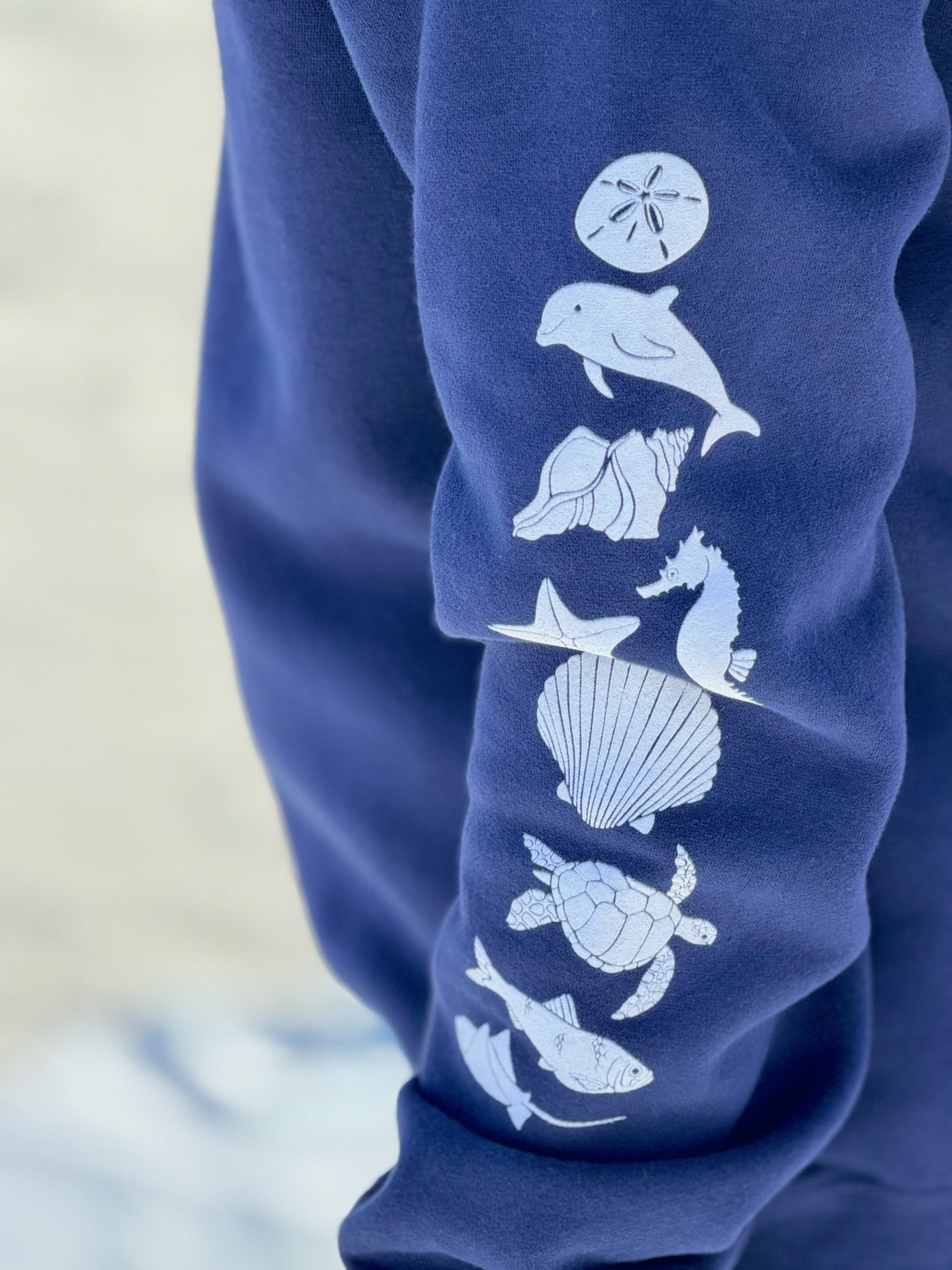 Close-up of sea life sleeve design on navy relaxed coastal crewneck sweatshirt