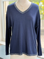 A navy blue lightweight sweater with silver trim on the V-neckline and bottom hem, displayed on a mannequin.