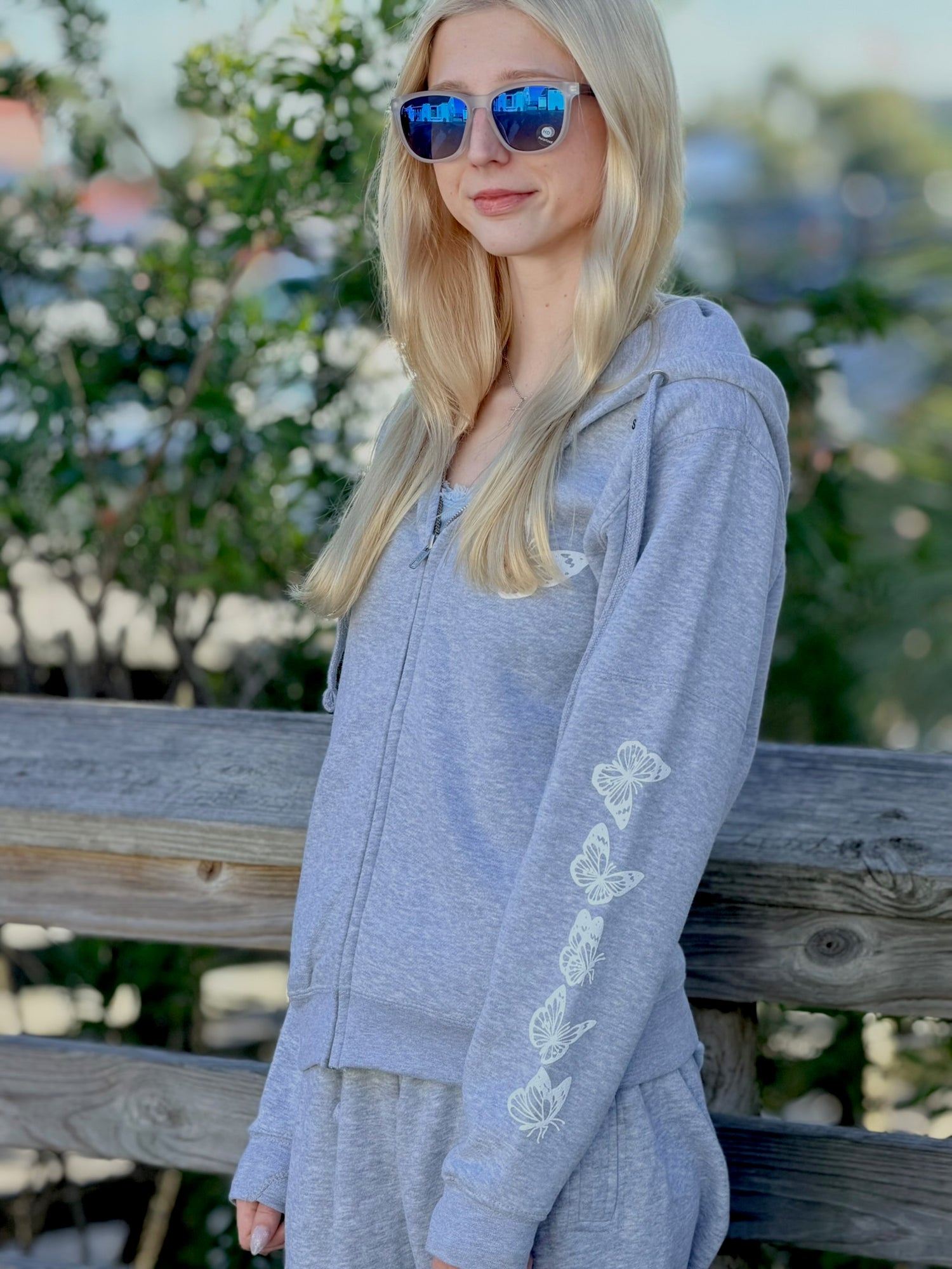 Women’s butterfly Zip-up hoodie with chest butterfly graphic, butterfly sleeve design, drawstring hood and ribbed trim at Ardor Boutique.