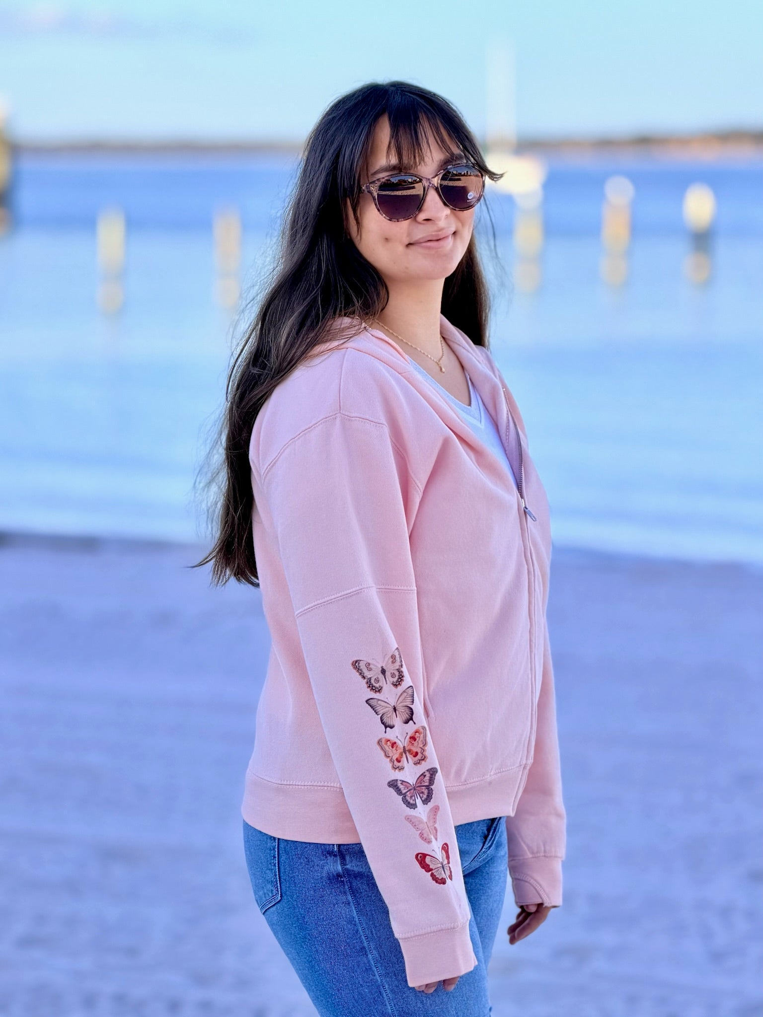 woman wearing red and pink butterfly zip beach in background