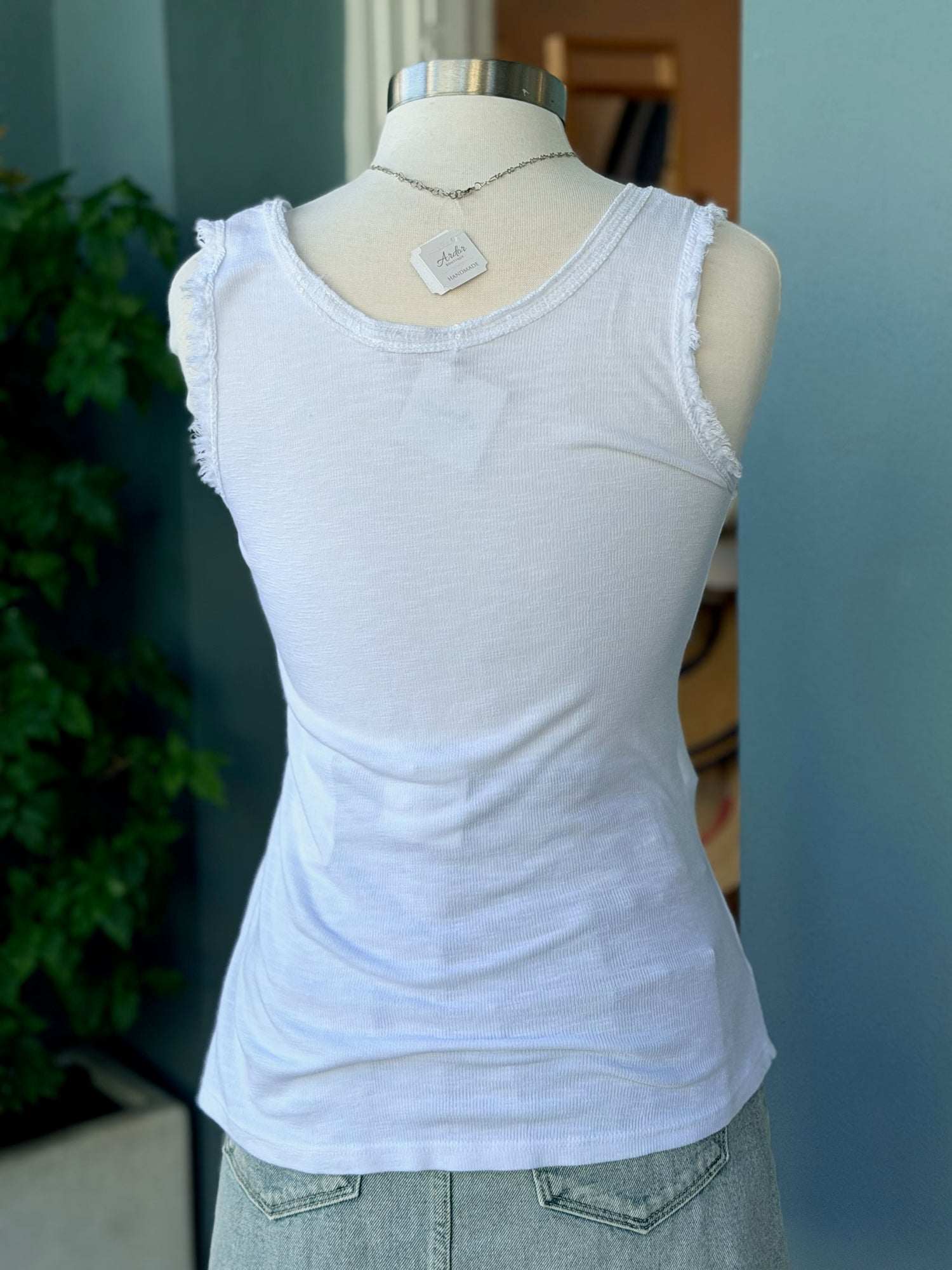 White tank top on a mannequin with a blurred background