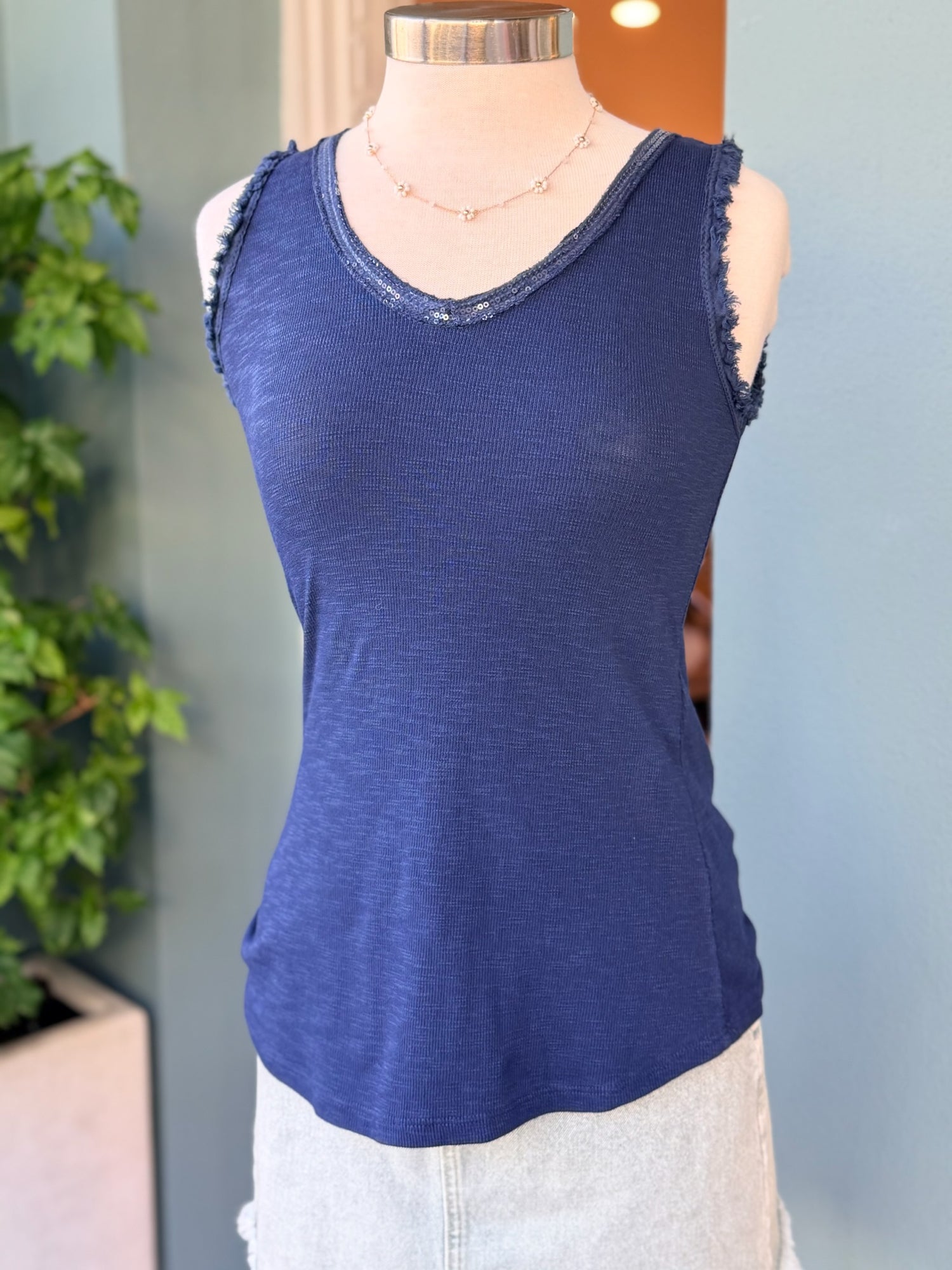 Navy sleeveless tank top with subtle sequin-trimmed V-neckline on a mannequin