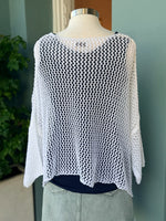 White crochet top on a mannequin against a neutral background