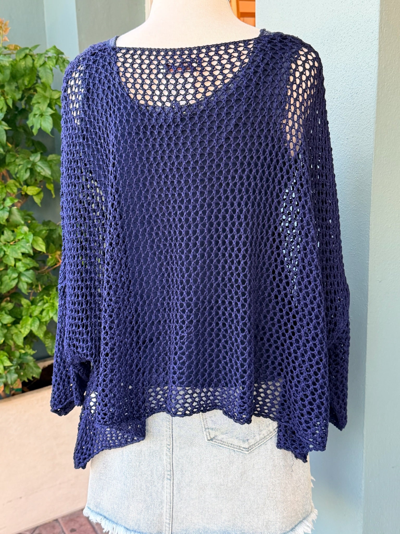 Navy blue crochet top on a mannequin against a light background