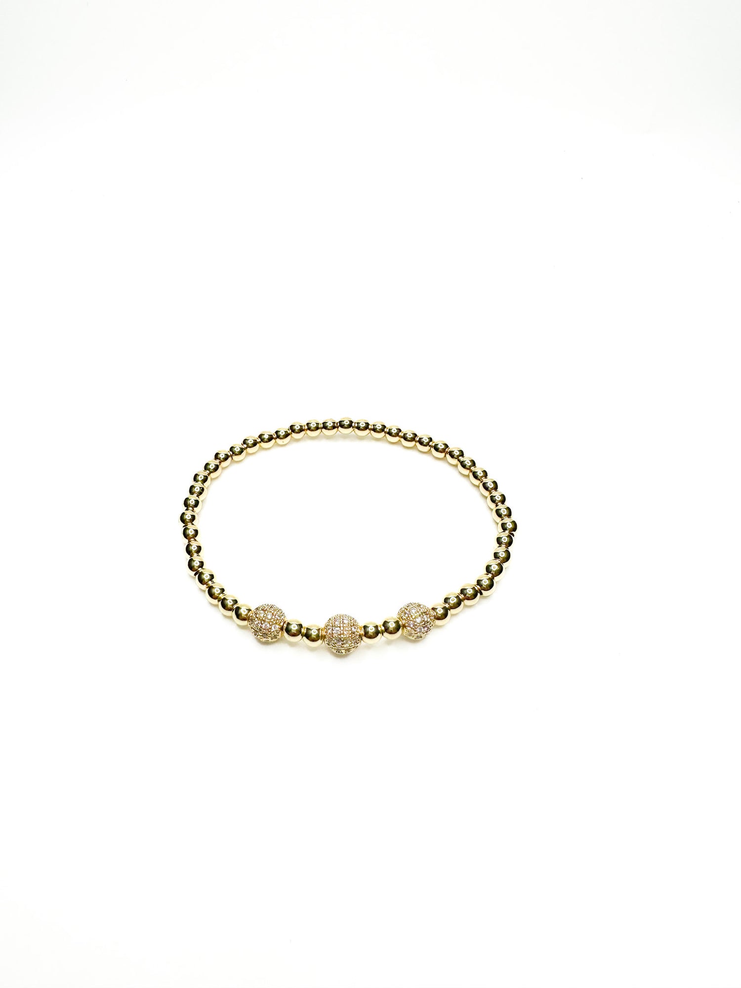 Gold bracelet with three beads on a white background