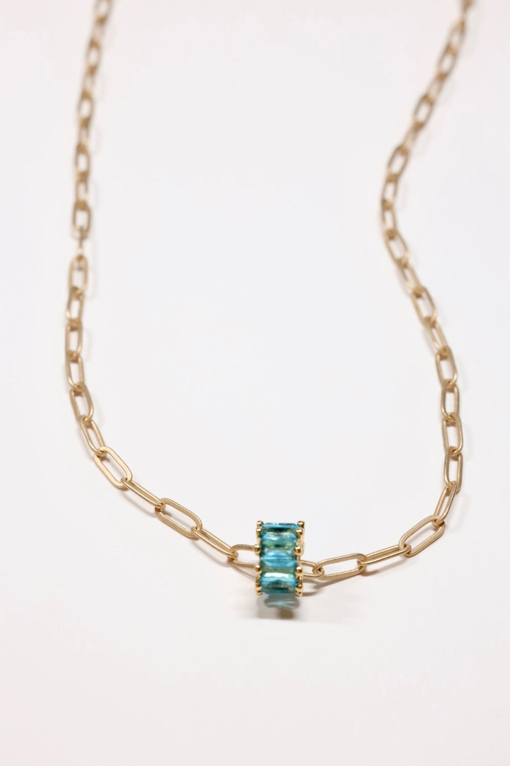 Aqua Crystal rondel necklace in gold on flat lay 