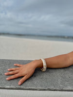 "Elise cloisonné bracelet worn at the beach – dove grey enamel with gold flowers