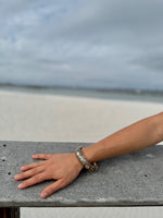 “Elise cloisonné bracelet worn at the beach – brown enamel with gold flowers”